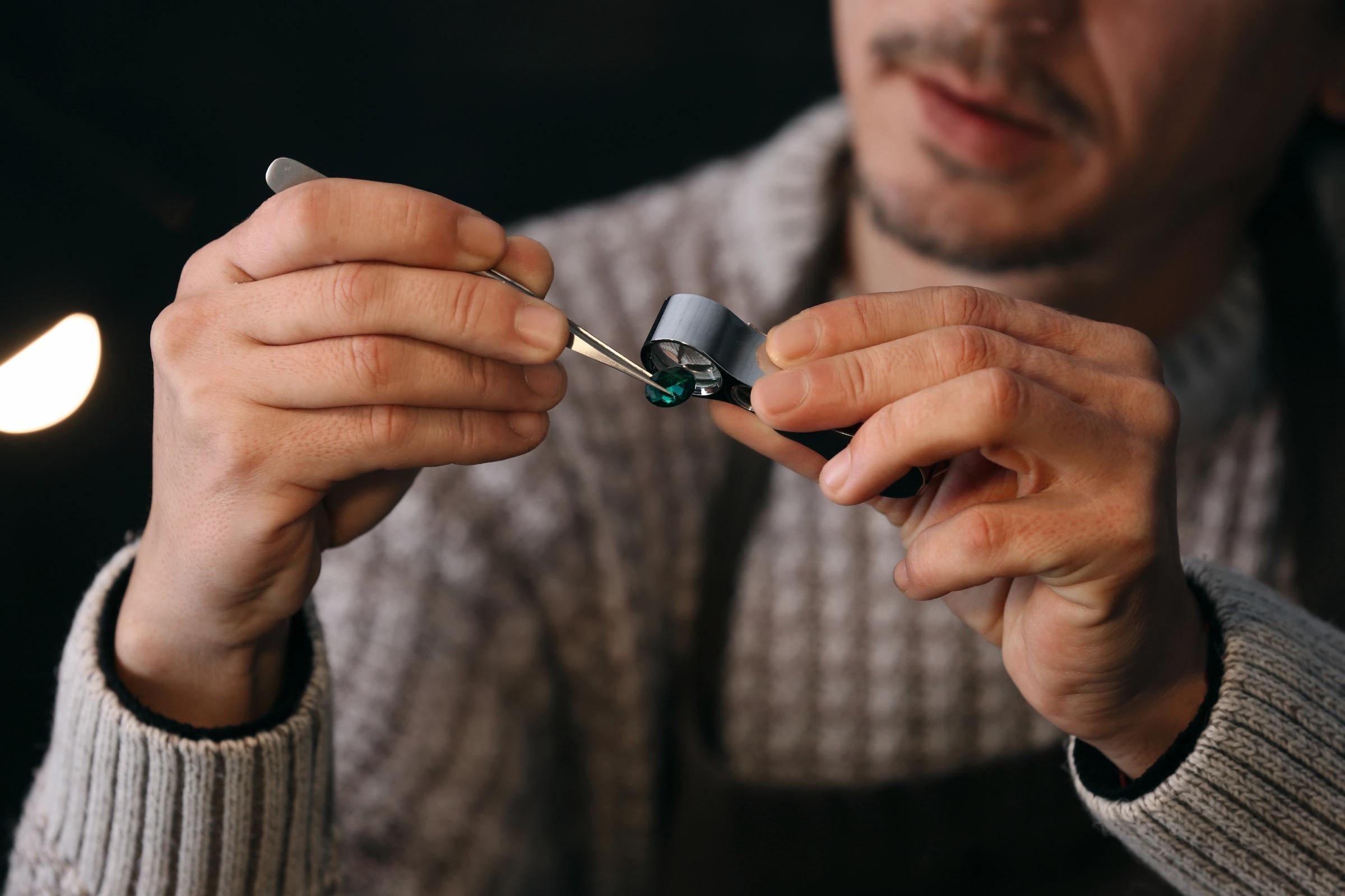 Jeweller examining gemstone in workshop