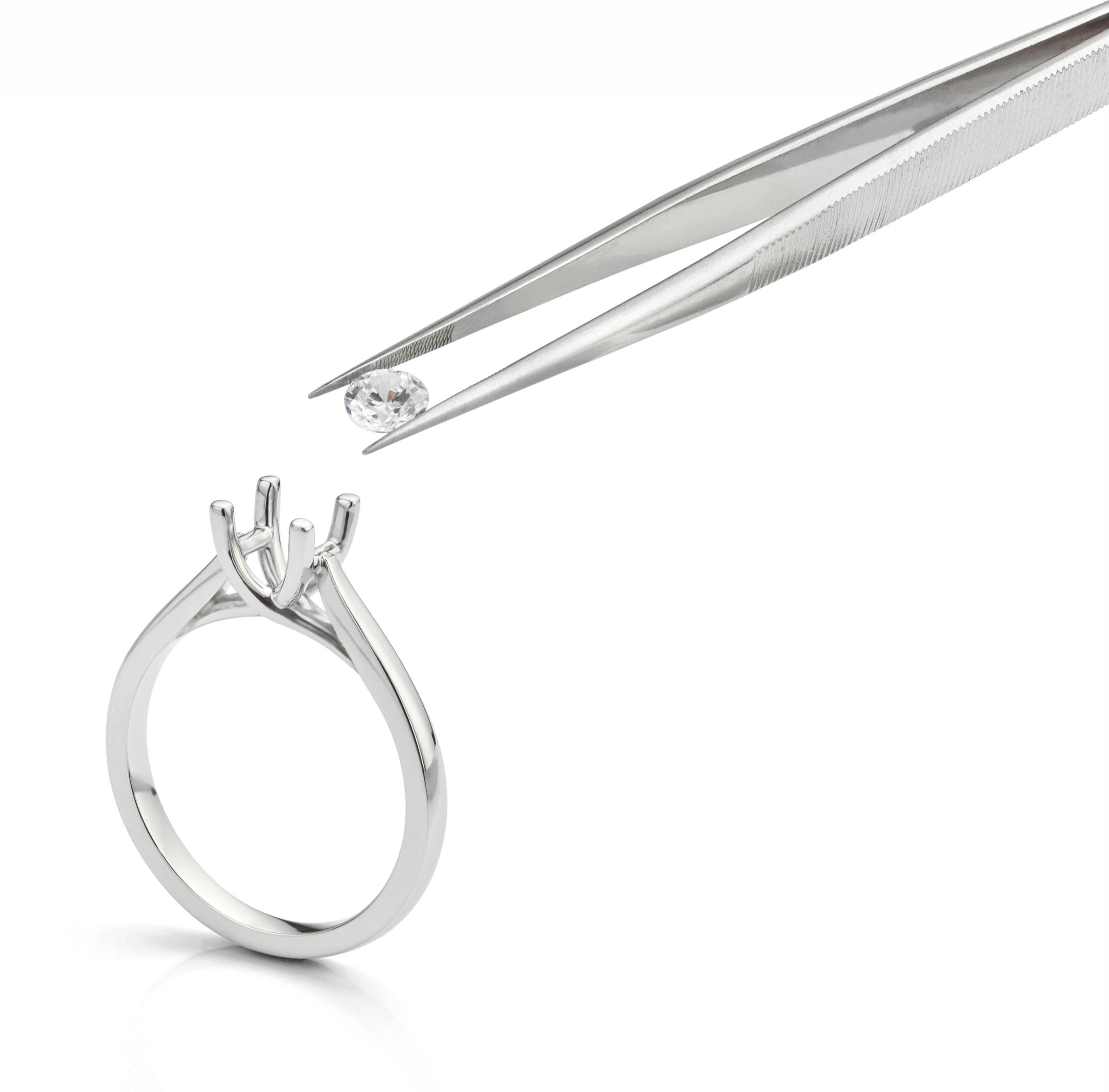 Diamond being set into engagement ring mount with tweezers