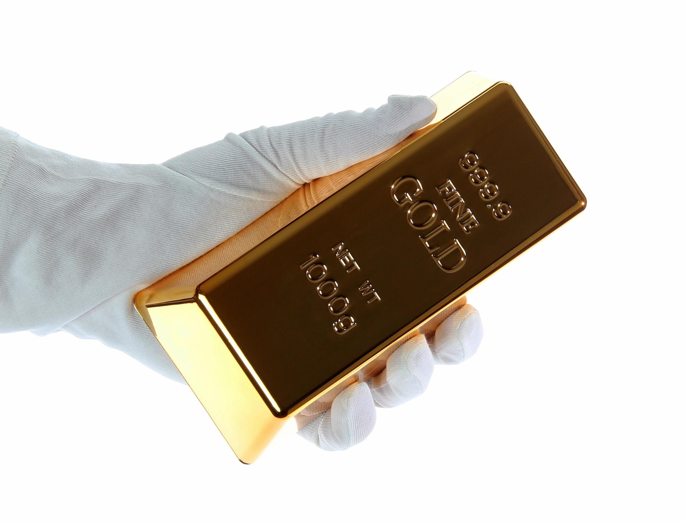 Gold bar held in white gloves — precious metal authenticity