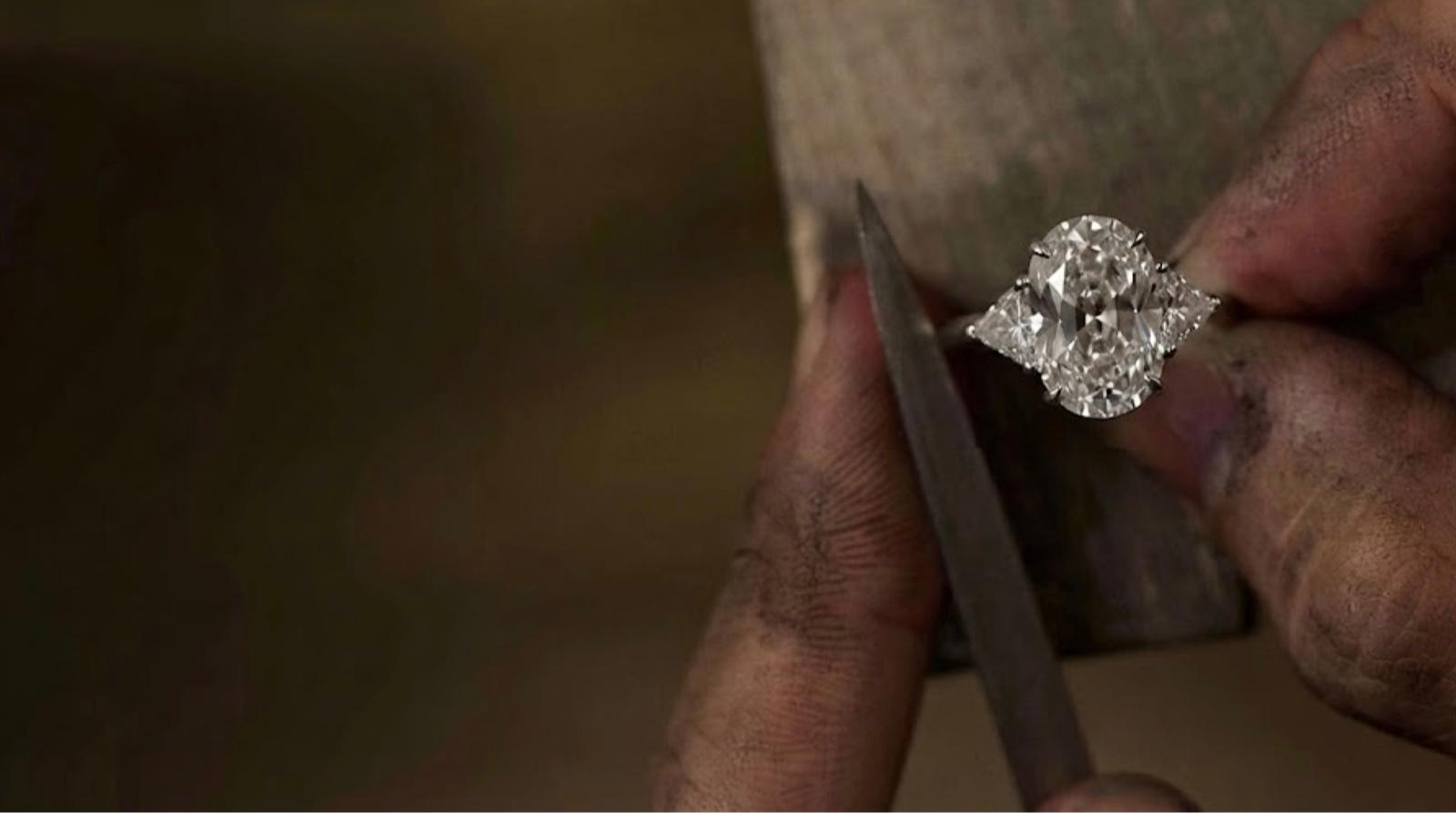 MOH craftsman in MYOTHERHALF apron examining a bespoke ring with tweezers