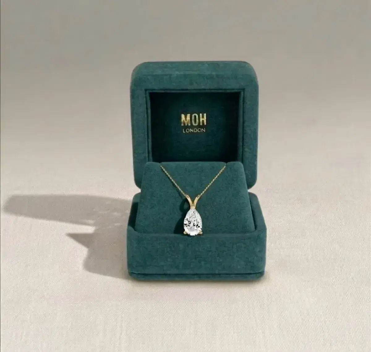 Pear diamond pendant in MOH London teal jewellery box