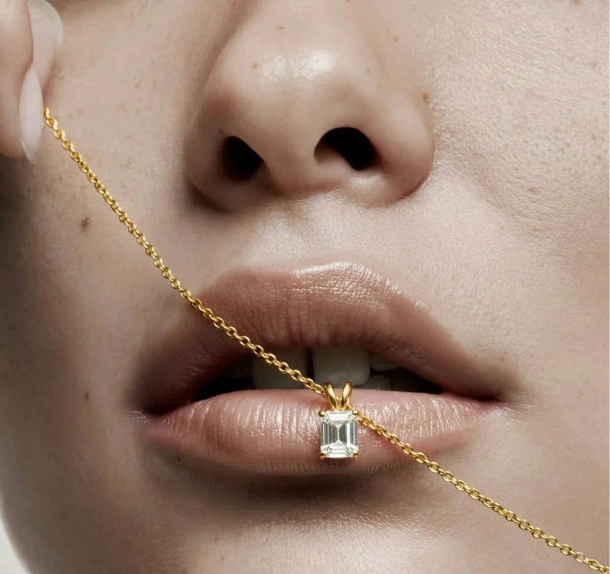Emerald-cut diamond pendant on chain — editorial close-up