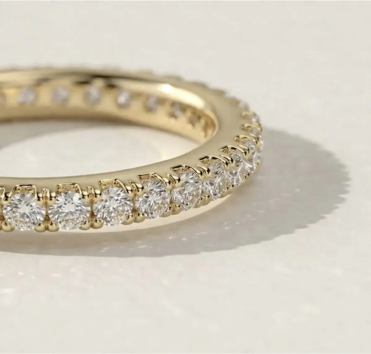 Round diamond eternity band in yellow gold — close-up detail