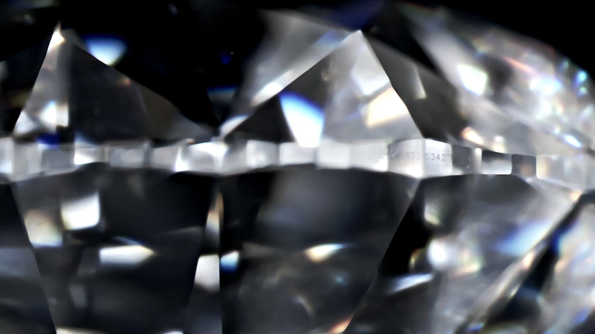 Brilliant-cut diamond rotating on black background
